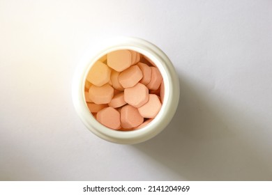 Orange Pill Top View Inside Bottle In Pharmacy With Sun