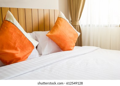 Orange Pillow And White Blanket On Bed In Bedroom With Lighting Upper Right Side