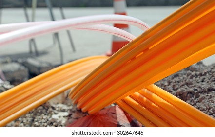 Orange Pipes For Fiber Optics In A Large City Road Construction To Connect High Speed Internet