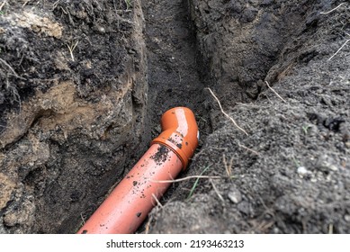 An Orange Plastic Pipe From A Septic Tank With A Diameter Of 160 Mm Lying In A Ditch.