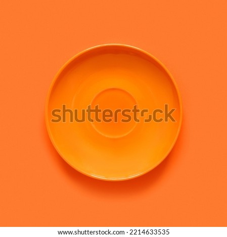 Orange plates on orange table. Monochrome minimalistic image in hipster style.Flat lay, top view, copy space for text. Creative background.