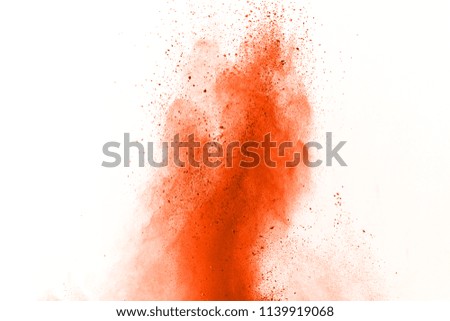 Orange powder explosion isolated on white background. Freeze motion of colored dust splatted.