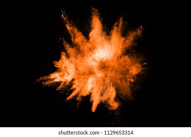 Orange powder explosion on black background. Colored cloud. Colorful dust explode. Paint Holi.
