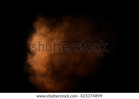Orange powder explosion on black background. Colored  cloud. Colorful dust explode. Paint Holi.