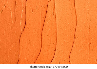 Orange pumpkin mask (facial cream, turmeric body scrub) texture close up, selective focus. Abstract background with brush strokes. 