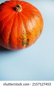 Orange Pumpkin On Blue Background. Autumn Background. Vertical Orientation. Copy Space. 