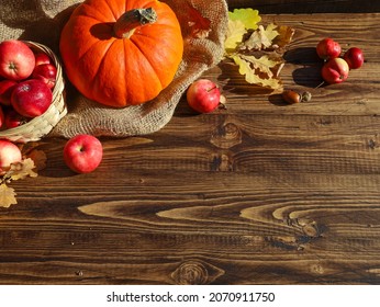Orange pumpkin, red apples on sackcloth top view. Dry yellow oak leaves, acorns on wooden table at brown wood barn wall background. Autumn, fall menu, holiday, thanksgiving, harvest season concept - Shutterstock ID 2070911750