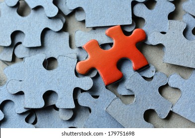 Orange Puzzle Piece Standing Out Of The Rest Of Puzzle Pieces. Conceptual Photograph To Display Business, Personal, Financial Success, Or A Leadership Concept. No People. Copy Space