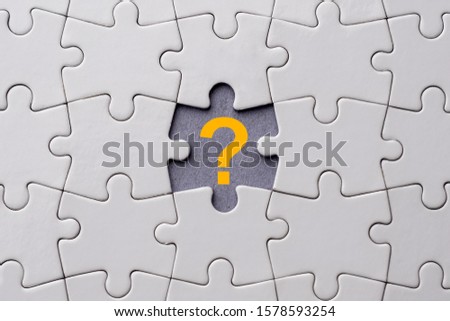 Orange question mark placed on last piece of jigsaw puzzle