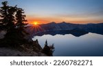 Orange Rays from Sunset Behind Mountains Over Crater Lake National Park