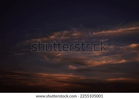 Orange red sunset. Dark violet blue evening sky with clouds. Background for design. Dramatic skies.