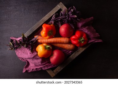 Orange And Red Vegetables On A Red Napkin In A Wooden Box Dark Photo