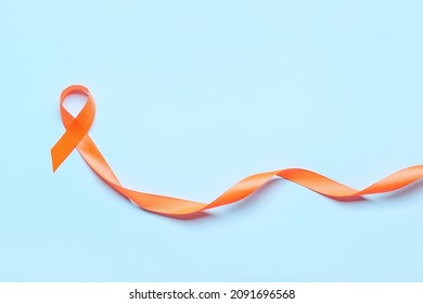 Orange Ribbon On Color Background. Cancer Leukemia Awareness Concept