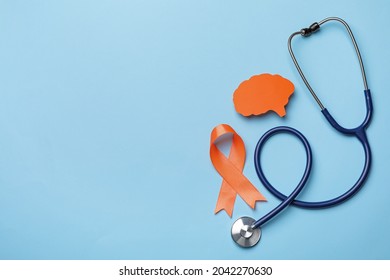 Orange ribbon, stethoscope and paper brain cutout on light blue background, flat lay with space for text. Multiple sclerosis awareness - Shutterstock ID 2042270630