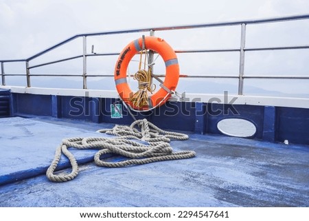 Orange ring lifebuoy on big ferry boat. Obligatory ship equipment. Personal flotation device. Prevent drowning. Orange lifesaver on the deck of a cruise ship. Traveling to an island