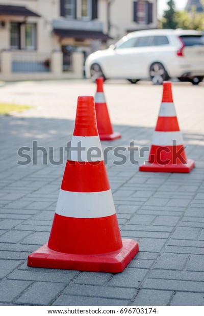 Orange road cone staying\
at the street.