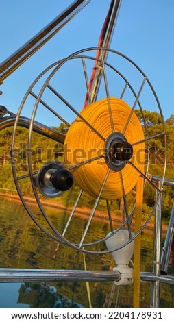 Orange rope reel on the yacht board on sunset