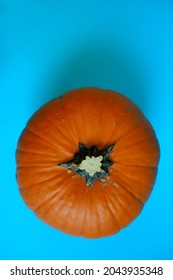 Orange Round Pumpkin Lies On A Blue Background.  View From Above