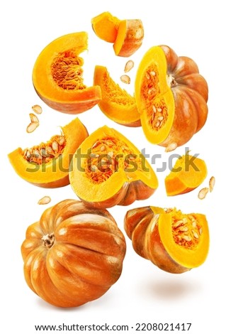 Orange round pumpkins, pumpkin slices with pumpkin seeds falling down on white background. File contains clipping paths.