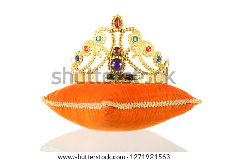 Orange royal velvet pillow with crown isolated over white background