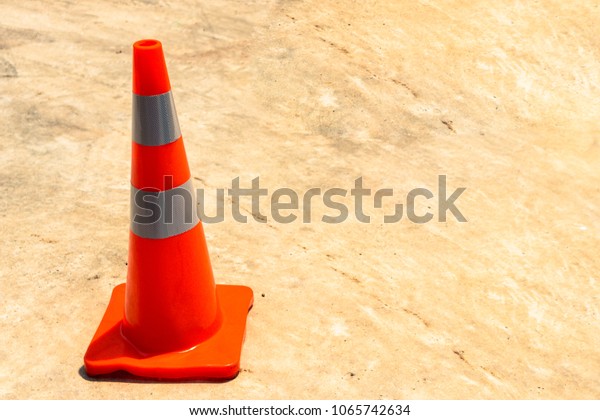 Orange rubber cone on the concrete road,  Orange
and gray cone,