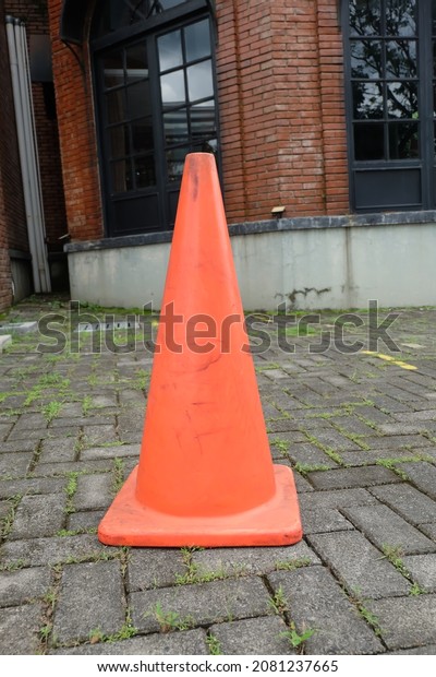 Orange rubber traffic\
cone on the road