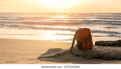 Orange rucksack, backpack   on the seaside against the sea at sunset. Travel concept. - Shutterstock ID 2275312285