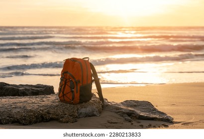 Orange rucksack, backpack   on the seaside against the sea at sunset. Travel concept. - Shutterstock ID 2280213833
