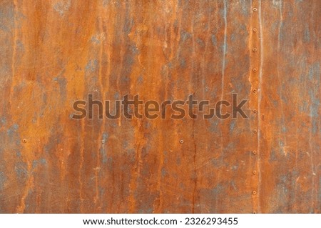 orange rust stains on weathered steel plate or yellow iron table and old brown metal wall by moisture with rivet nut head for dirty board background or red retro backdrop ancient texture on top view