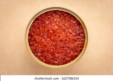 Orange Salmon Caviar In A Tin Can On Craft Brown Paper. Red Caviar In A Jar Close-up, Seafood. Delicacy Food Concept.