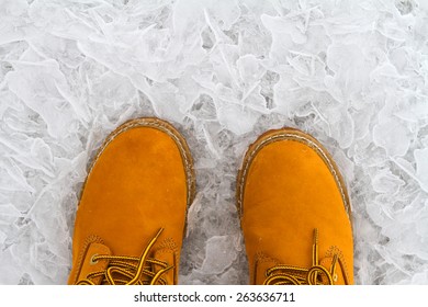 Orange Shoes Standing On The Thin Broken Ice