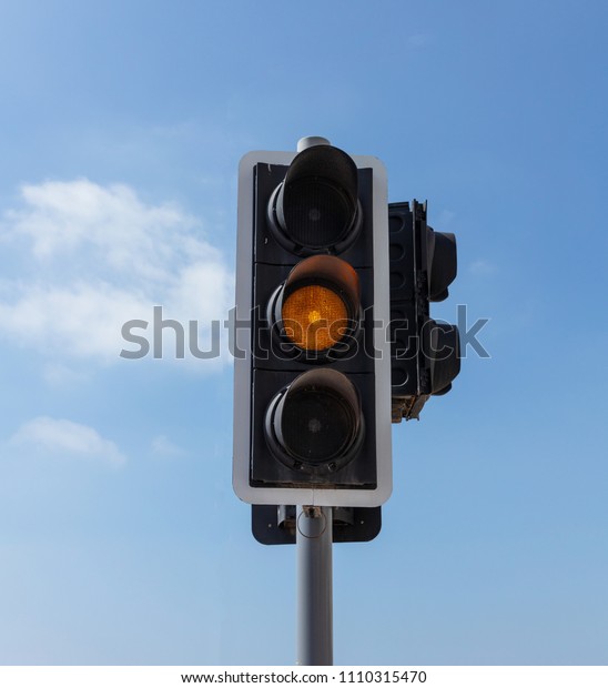 Orange signal, urban traffic lights for cars,
blue sky background