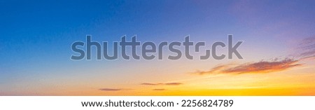 orange sky and clouds background,Real majestic sunrise sunset sky background with gentle colorful clouds without birds.Panorama, large