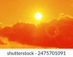 Orange sky with sun and clouds during hot summer weather