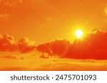 Orange sky with sun and clouds during hot summer weather