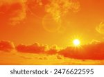 Orange sky with sun and clouds during hot summer weather