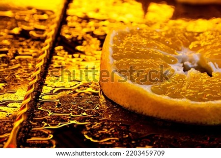 orange slice. close up of orange fruits on table. orange slice for cocktail. cocktail mixer spoon. orange with water drops. neon yellow lighting for fruit.