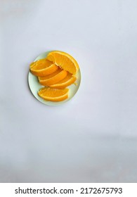 Orange Slice, Sunkist Orange On Soft Green Small Plate Isolated On White Background