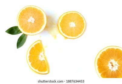 Orange Slices With Green Leaves And Spilled Orange Juice On A White Background, Top View, Close Up.