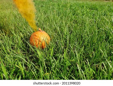 Orange Smoke Bomb Firework On Grass