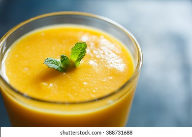 orange smoothie with mint in the glass, top view