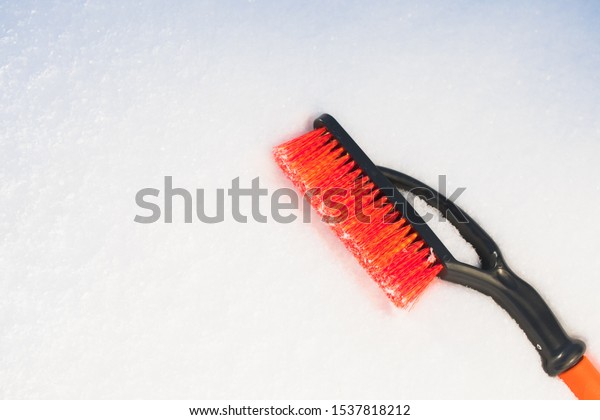 orange snow\
brush for car, snowflakes\
background