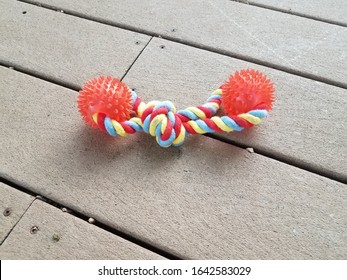 Orange Spiky Rubber And Rope Dog Toy On Wood