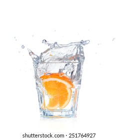 Orange Splashing Into Glass Of Water On White Background