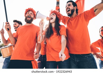 Orange Sport Fans Screaming While Supporting Their Team Out Of The Stadium - Football Supporters Having Fun At Competion Event - Soft Focus On Center Girl Face