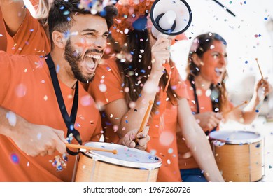 Orange Sport Fans Screaming While Supporting Their Team Out Of The Stadium - Football Supporters Having Fun At Competion Event - Focus On Man Face