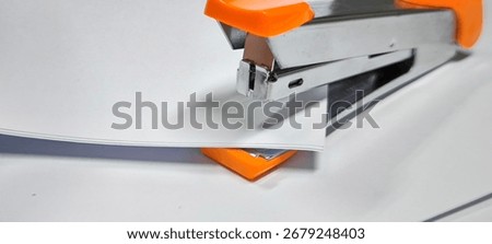 Orange stapler on white background