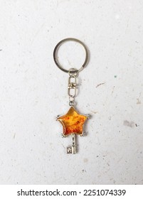 An orange star key with glitter epoxy resin keychain on a white background - Shutterstock ID 2251074339