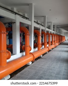 An Orange Steel Pipe Of Clear Water From Filtration Process In Water Treatment Plant Taken From The Empty Dusty Alley Inside The Building