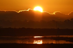 Orange Sunrise In The Morning Over Water At Bolsa Chica Ecological Reserve California, USA